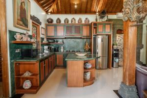 a kitchen with wooden cabinets and a refrigerator at Villa Joglo Ayu in Uluwatu