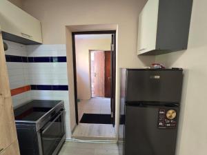 a kitchen with a refrigerator and a door to a hallway at Апартаменти CENTER in Uzhhorod