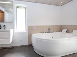 a white bath tub in a bathroom with a window at 4 star holiday home in Knebel in Knebel +30 photos