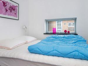 a bed with a blue comforter in a bedroom at 4 star holiday home in Knebel in Knebel