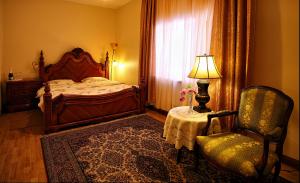 a bedroom with a bed and a chair and a lamp at Oškrogs in Ķegums