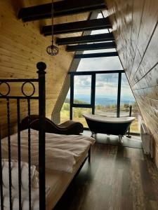 a bedroom with a bed and a bath tub and a window at La Popasul Cerbului in Semenic