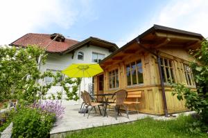 a patio with a table and chairs and a yellow umbrella at Vila Krivec in Bled