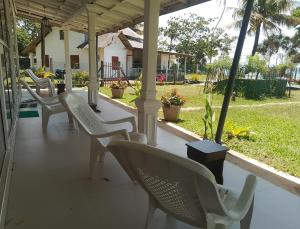 a row of white chairs sitting on a porch at Albergo Marina Nilwella in Dickwella