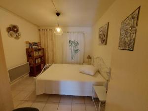 ein Schlafzimmer mit einem weißen Bett in einem Zimmer in der Unterkunft Cap d'Agde, appartement bord de mer, 50 m plage de la Roquille, climatisé et WIFI, in Cap d'Agde + 16 Fotos