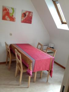 una sala da pranzo con tavolo e sedie rosa di Gite Kaefferkopf ad Ammerschwihr