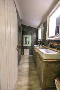 a large bathroom with a sink and a door at La Pazienza in Marina di Gairo