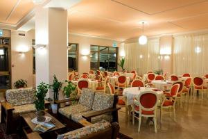 a dining room with tables and chairs and tablesktop at Hotel Europa in Porlezza