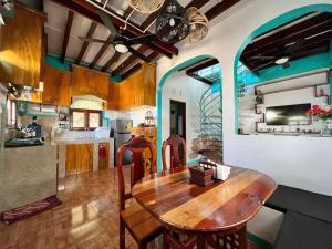 a kitchen and dining room with a wooden table at Casa De Moore - Ocean & Garden View Siargao in General Luna
