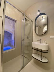a bathroom with a shower and a sink and a mirror at Suite Prima Pietra with mini pool in Ostuni