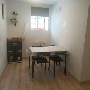 a dining room table with four chairs and a window at Cornisa Tourists Home in Toledo