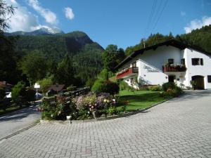 a small white building with flowers in front of it at Haus Kehlstein in Ramsau