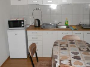 cocina con fregadero, mesa y sillas en apartman kostrena, en Kostrena