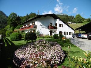 una casa blanca con flores delante en Haus Kehlstein, en Ramsau