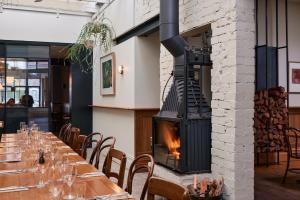 a fireplace in a restaurant with a long table at Naughtons Hotel in Melbourne