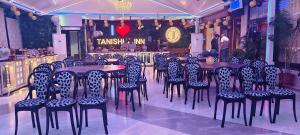 a restaurant with tables and chairs in a room at Hotel Tanishka Inn in Mathura