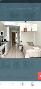 a white bedroom with a bed and a kitchen at Studio Lintulammentie in Oulu