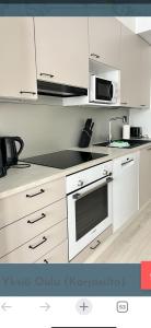a kitchen with white cabinets and a stove top oven at Studio Lintulammentie in Oulu