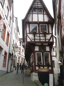 un bâtiment dans une rue où les gens marchent dans une rue dans l'établissement Hotel-Restaurant Kastel, à Bernkastel-Kues