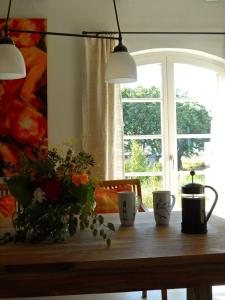 a table with cups and flowers on it with a window at Ferienwohnung Gurvitz in Rambin