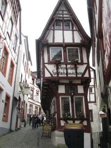 een gebouw in een straat waar mensen over straat lopen bij Hotel-Restaurant Kastel in Bernkastel-Kues