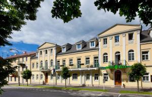 un grand bâtiment jaune dans une rue de la ville dans l'établissement Hotel Reza, à Františkovy Lázně