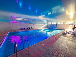 a swimming pool with purple lights in a building at Safari Resort & Convention Centre in Boorama