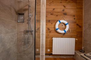 a bathroom with a shower with a lifesaver on the wall at La Voûte Des Oliviers in Bessas +14 photos