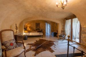 a bedroom with a bed and a chair in a room at La Voûte Des Oliviers in Bessas