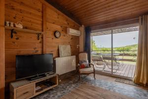 a living room with a tv and a large window at La Voûte Des Oliviers in Bessas