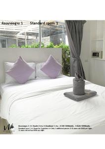 a bedroom with a bed with purple pillows at Koh Larn White House in Ko Larn