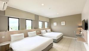 a hotel room with two beds and a tv at Country Inn in Johor Bahru