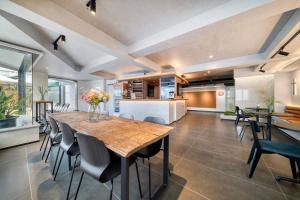 a kitchen and dining room with a wooden table and chairs at Wander Lodge Youth Hostel in Chengdu