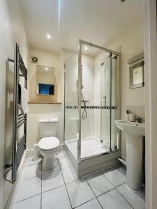 a bathroom with a shower and a toilet and a sink at London Modern Flat near transports in London