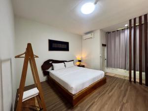 a bedroom with a white bed and a wooden ladder at YAYO coffee and bed in Chiang Rai