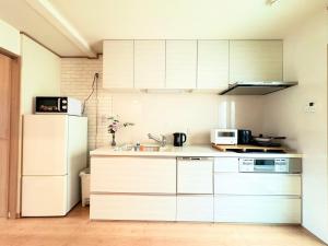 a kitchen with white cabinets and a white refrigerator at 夏様二条南 6 min walk Nijo St, Entire private house, 3 bedrooms, Up to 6 guests, 2 toilets in Kyoto