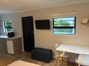 a room with a desk and a table and a window at Suburban Bliss in Stellenbosch