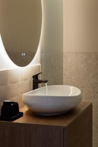 un bagno con un lavandino bianco e uno specchio di M&M Urban Escape a Arad