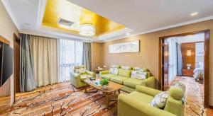 a living room with green couches and a table at Liyuan Hotel in Shenzhen