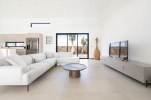 a white living room with a white couch and a table at La Villa Boz in Grand Gaube