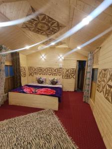 een kamer met een bed en een tapijt erin bij Little blue Moon in Srinagar +1 foto