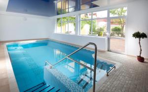 a large swimming pool with a staircase in a house at Hotel Reza in Františkovy Lázně