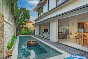an indoor pool with a fire pit in the middle of a house at Lacasa2 Villa Legian With Butler in Legian