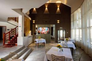 a dining room with tables and chairs and a television at Pensiunea Crystal in Iaşi