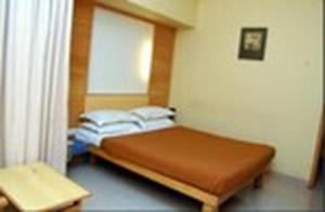 a small bedroom with a bed and a window at Hotel City Park, Solapur in Solapur