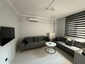 ein Wohnzimmer mit Sofa und Tisch in der Unterkunft PP Hotel in Burunabat