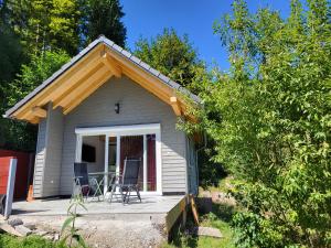 a small house with a porch and a table and chairs at BlackforestBike&HikeHouse in Baiersbronn