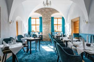 a restaurant with tables and chairs and a chandelier at Resort Schloss Auerstedt in Auerstedt