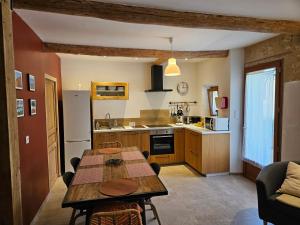 een keuken met een houten tafel en een eetkamer bij Le nid douillet in Pertuis