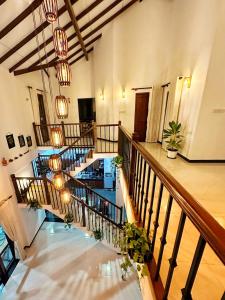 a lobby with a staircase with potted plants and lights at Casa Araliya in Negombo